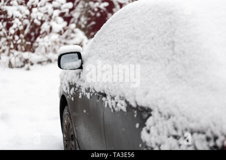 Dirty car covered by thick snow layer with selective focus. Stock Photo