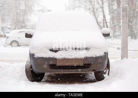 Old dirty car covered by thick snow layer with selective focus Stock Photo