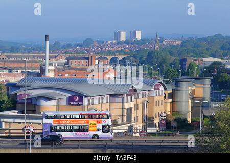 A bus travels along the A58M in Leeds, with Kirkstall in the background. Stock Photo