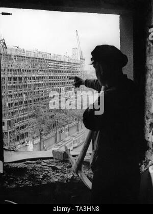 A construction worker points at the Haus des Fremdenverkehrs (House of Tourism), that is currently under construction. Stock Photo