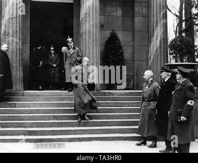 After the wreath laying at the sarcophagus of Wilhelm I in the Mausoleum of Charlottenburg Palace, the Crown Prince (middle, on the stairs) leaves the building in Hussar uniform. Crown Princess Cecilie (left in the door) follows her husband. At the foot of the stairs stands Prince Oskar of Prussia (3rd from right). Stock Photo