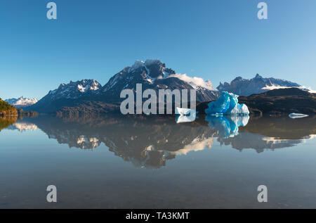 The peaks of Torres and Cuernos del Paine national park and iceberg with reflections in Lago Grey or Grey Lake near Puerto Natales, Patagonia, Chile. Stock Photo