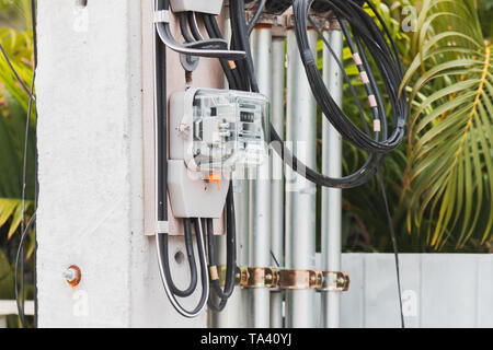 Thai Metropolian Electricity Authority watt hour meter install on electricity pole in a village. This meter measure how much electricity was used Stock Photo