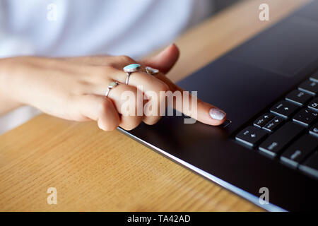 Close up photo of woman touching laptop fingerprint sensor with her finger to log in into system. Biometric fingerprint print scan provides security a Stock Photo