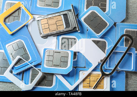 Many sim cards with slot and key on grey background Stock Photo