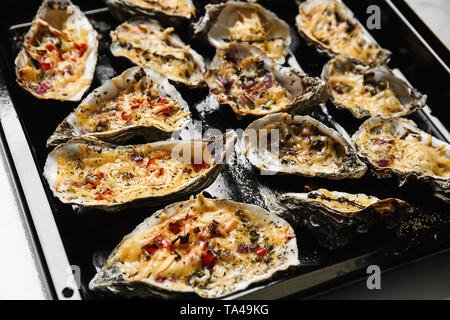 Tasty cooked oysters on baking sheet, closeup Stock Photo