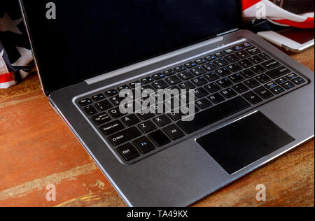 Open laptop of office supplies and gadgets on old wooden desk Stock Photo