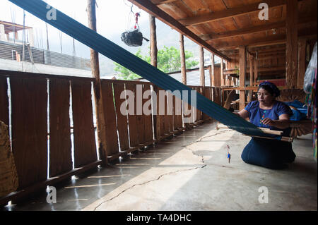 A maya indigenous woman weaves on backstrap loom in San Antonio Palopo, Solola, Guatemala. Stock Photo
