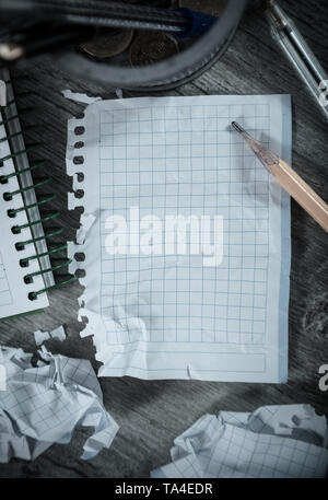 Crumpled empty pages and notebook lying on wooden surface Stock Photo
