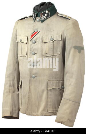 A summer field tunic of an SS-Hauptsturmführer of the infantry found in Normandy Light field-grey cotton cloth with dark-green collar and metal buttons, unlined version with integrated hanger (shortened) and opening for the sidearm, Iron Cross ribbon, orders loops. The side darts have been let out. The collar and collar patches with moth holes. Black collar patches with runes embroidered in silver and silver cord trim. Sewn-on shoulder boards with black lining and white branch colour. The silhouette of the sleeve eagle still visible. Worn tunic bleached by the sun, with tra, Editorial-Use-Only Stock Photo