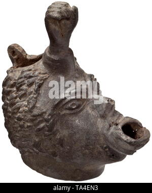 A Roman oil lamp shaped like an African head, 2nd - 3rd century Bronze lamp, the opening of which is fashioned as the pouting mouth of an African man. In combination with the bulging eyes and a hollow fist emerging from the forehead, the whole piece has a grotesque appearance. The hair styled in cropped, curly locks. The lid is missing on the back of the head, one hinge bracket still in place. Rare version of a common type with a fist on the forehead. Dark green patina. Length 9.6 cm, height 10.3 cm. Provenance: Viennese private collection, acqui, Additional-Rights-Clearance-Info-Not-Available Stock Photo