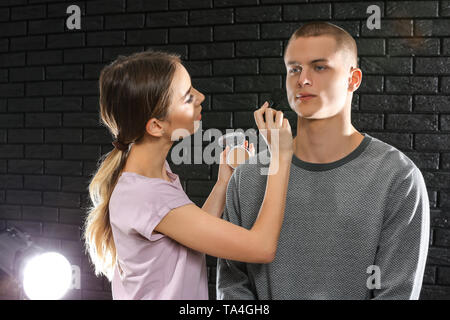 Professional makeup artist working with young model in photo studio Stock Photo