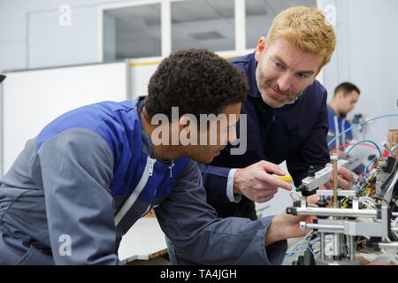 two technicians working on a machine in factory Stock Photo