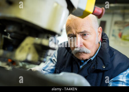 senior worker using a machine Stock Photo