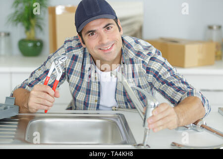 plumber assembling sink pipes Stock Photo