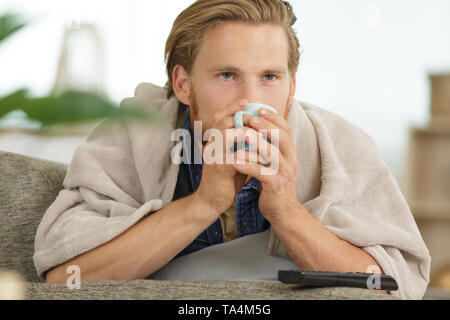 ill man suffering from illness on sofa at home Stock Photo