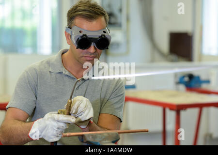 man wearing protective eyewear while using gas torch Stock Photo