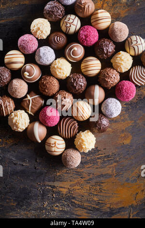 Rectangular still life of gourmet handmade chocolates on a rustic wood table viewed from above with copy space Stock Photo