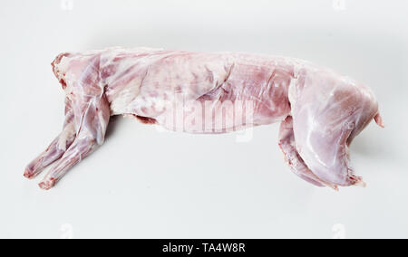 Skinned and cleaned carcass of a wild rabbit ready for roasting for a gourmet venison meal lying on white with copy space Stock Photo