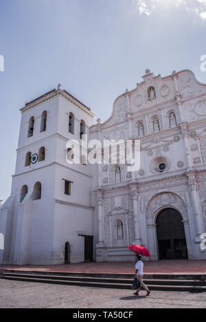 Person with umbrella walks in front of church Stock Photo