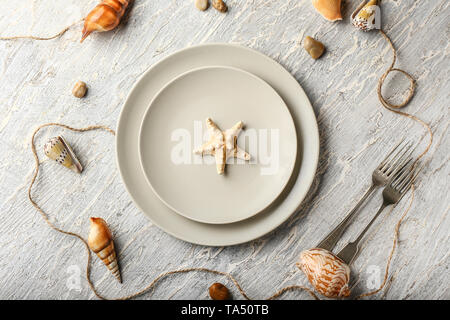 Beautiful table setting with marine decor on white wooden background Stock Photo