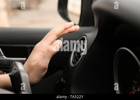 Woman checking operation of air conditioner in car, closeup Stock Photo