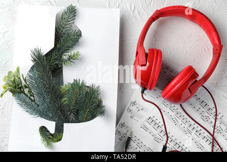 Composition with violin clef, note sheets and headphones on table Stock Photo