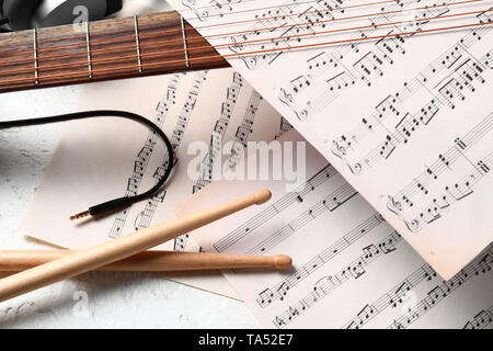 Composition with guitar, drumsticks and music sheets on white background Stock Photo