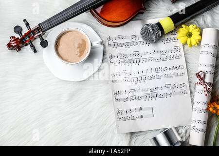 Composition with violin, cup of coffee and music sheets on fluffy plaid Stock Photo