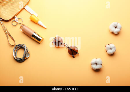 Stylish sunglasses with female items on color background Stock Photo