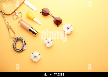 Stylish sunglasses with female items on color background Stock Photo