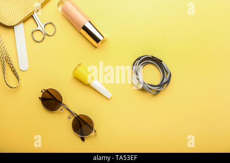 Stylish sunglasses with female items on color background Stock Photo