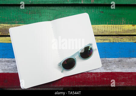 open blank white page book on colorful wooden background , decoration with sunglass fashion Stock Photo