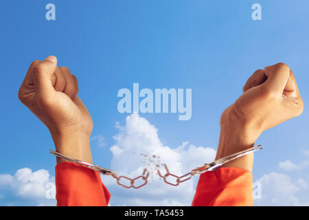 freedom concept. two hands of prisoner with broken handcuff for freedom meaning with blue sky at background Stock Photo