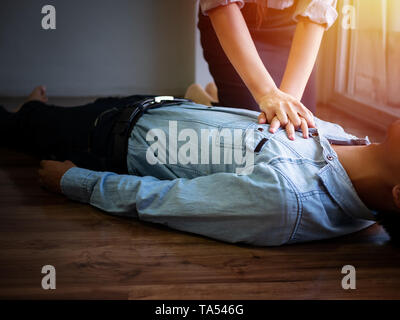 volunteer office woman use hand pump on chest for first aid emergency CPR on heart attack man unconscious, try to resuscitation patient man at work Stock Photo