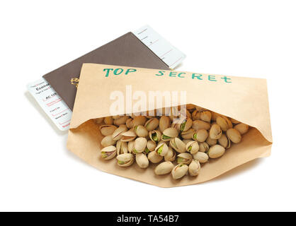 Envelope with text TOP SECRET and pistachio nuts, passport and tickets on white background Stock Photo