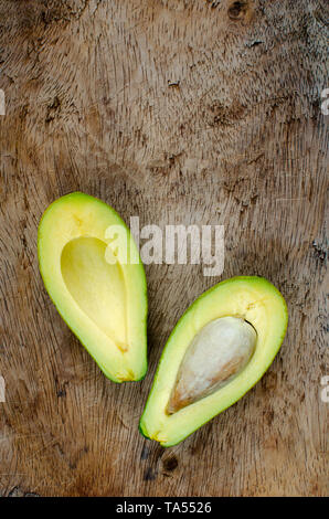 Halved avocado on a rustic cutting board Stock Photo