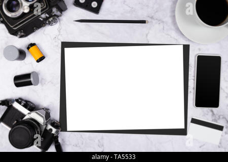 flat lay vintage camera on white marble background with white blank paper and photography tool Stock Photo