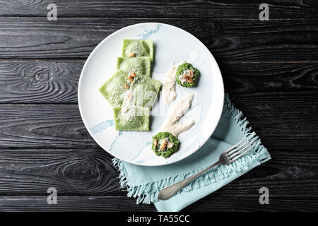 Plate with tasty ravioli on wooden table Stock Photo