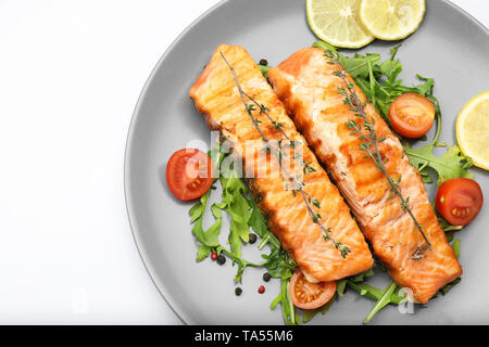 Plate with pieces of tasty grilled salmon, vegetables and spices on white background Stock Photo
