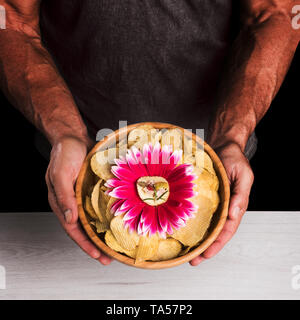 Man holds bowl with french fries and appetizers Stock Photo