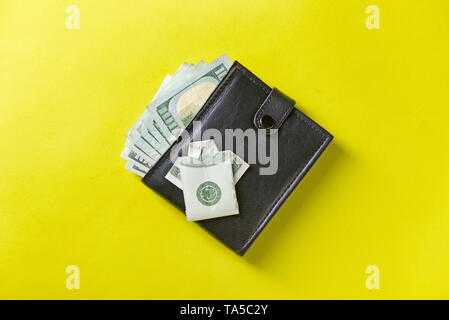 Wallet with money and origami shirt made of dollar banknote on color background Stock Photo