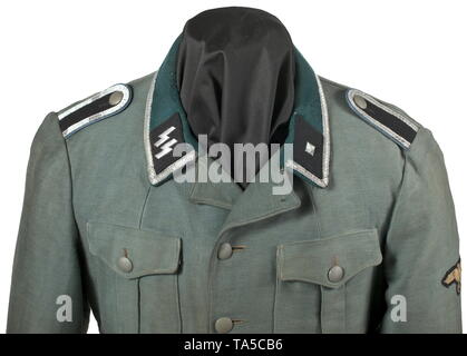 A field tunic M 36 of an SS-Unterscharführer in a transport or supply unit private purchase piece Summer issue made of dark field-grey moleskin with metal buttons and dark-green collar, with RZM belt hooks sewn into the side seams on the back, the sleeve ends in the style of the depot pieces, partially lined with brown cotton cloth. Silver braiding signifying the rank of Unterführer, black collar patches with runes and metal rank stars respectively, all embroidered in silver, sewn-on black shoulder boards with light-blue branch colour, machine-embroidered sleeve eagle on bl, Editorial-Use-Only Stock Photo