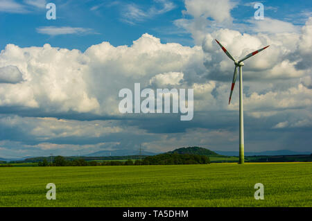 single wind turbine in rural area in front of storm cloud cumulus sky Stock Photo