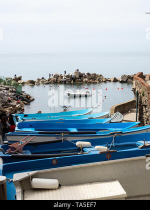 Riomaggiore, Italy - April 21, 2019 Fisherman boats aligned at the pier of Riomaggiore town in Cinque Terre Stock Photo