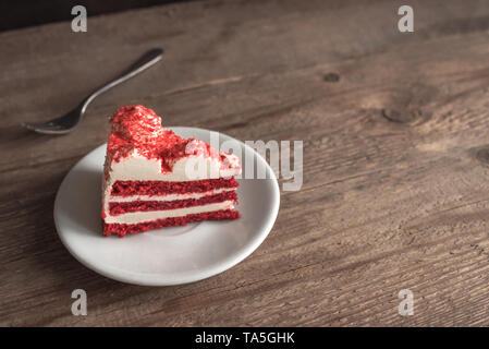 Red Velvet Cake. Piece of Red Velvet Cake on wooden table, copy space. Stock Photo