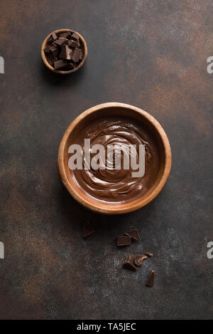 Chocolate Spread on dark background, top view, copy space. Homemade melted chocolate in bowl. Stock Photo