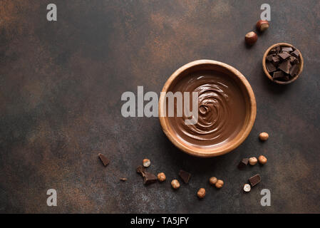 Chocolate Hazelnut Spread on dark background, top view. Homemade spread with chocolate and nuts. Stock Photo