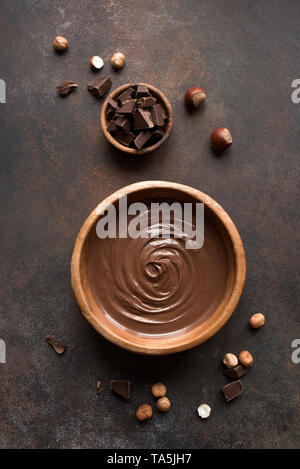 Chocolate Hazelnut Spread on dark background, top view. Homemade spread with chocolate and nuts. Stock Photo
