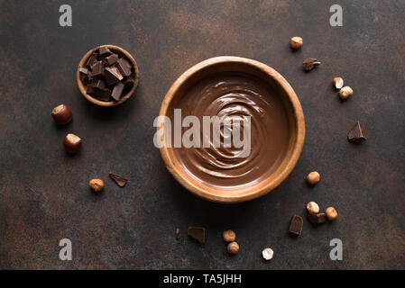 Chocolate Hazelnut Spread on dark background, top view. Homemade spread with chocolate and nuts. Stock Photo